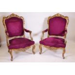 A pair of giltwood open armchairs with carved and pierced decoration