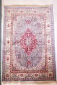 A duck egg blue ground Kashmir carpet with an ornate floral medallion design and an ivory border,