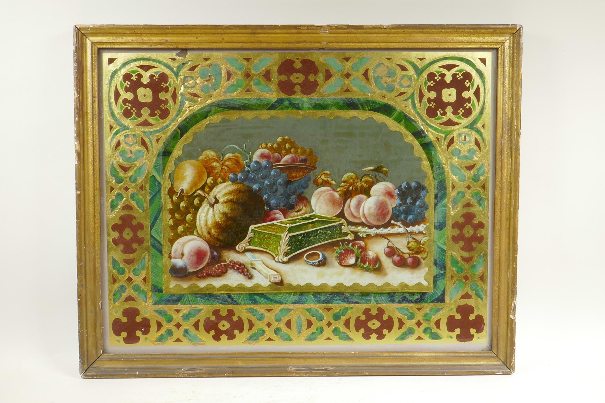 A C19th eglomise and reverse painted still life of fruit, with Gothic Revival decoration, in a