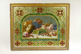 A C19th eglomise and reverse painted still life of fruit, with Gothic Revival decoration, in a