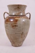 A stoneware storage jar and cover, with two handles, 23" high