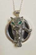 A sterling silver pendant necklace decorated with a panther with inset green stone eyes, 2" drop