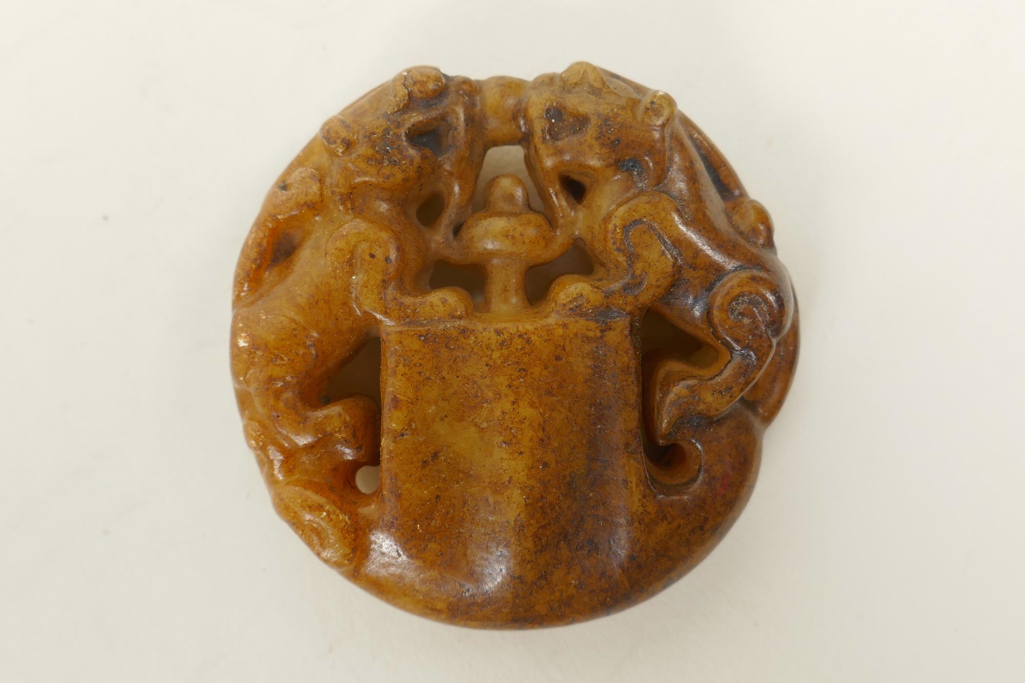 A Chinese russet hardstone pendant with carved twin kylin decoration, 2" diameter - Image 2 of 2