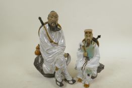 A Chinese, Shiwan style, figure of a warrior resting on a rock, 9½" high, together with a similar