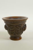 A Chinese faux horn libation cup with two carved handles in the form of a climbing kylin,