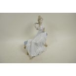 A Spanish D'Art. SA porcelain figure of a girl in a long dress seated on a chaise, 10½" high