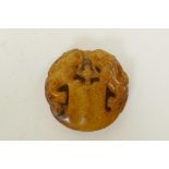 A Chinese russet hardstone pendant with carved twin kylin decoration, 2" diameter