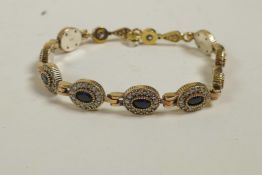 A 925 silver gilt bracelet set with blue hardstones encircled by cubic zirconium, 8" long