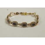 A 925 silver gilt bracelet set with blue hardstones encircled by cubic zirconium, 8" long