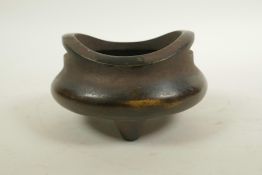 A Chinese bronze censer with phoenix eye handles and tripod supports, impressed two character mark