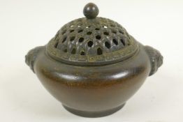 A Chinese bronze incensor with lion mask handles and pierced basket pattern cover, 4½" diameter