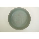 A Chinese Song style celadon glazed porcelain bowl with raised kylin and flaming pearl decoration to