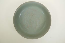 A Chinese Song style celadon glazed porcelain bowl with raised kylin and flaming pearl decoration to