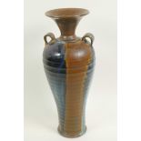 A Chinese stoneware baluster vase with rib formed body and two loop handles, drip glazed in brown