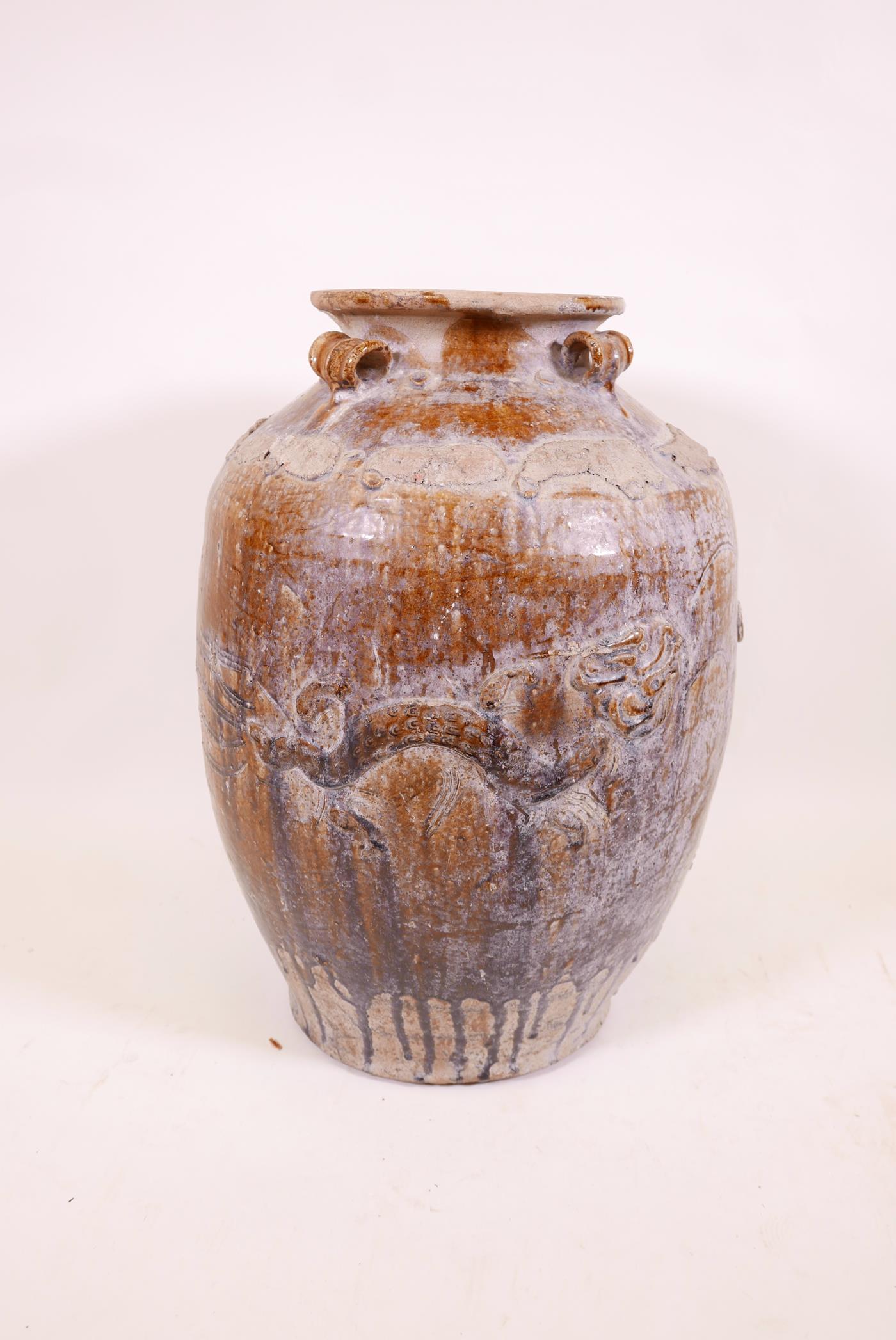 A large Chinese treacle glazed jar with four moulded ring handles, 26" high