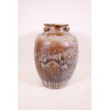 A large Chinese treacle glazed jar with four moulded ring handles, 26" high