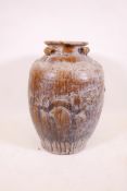 A large Chinese treacle glazed jar with four moulded ring handles, 26" high