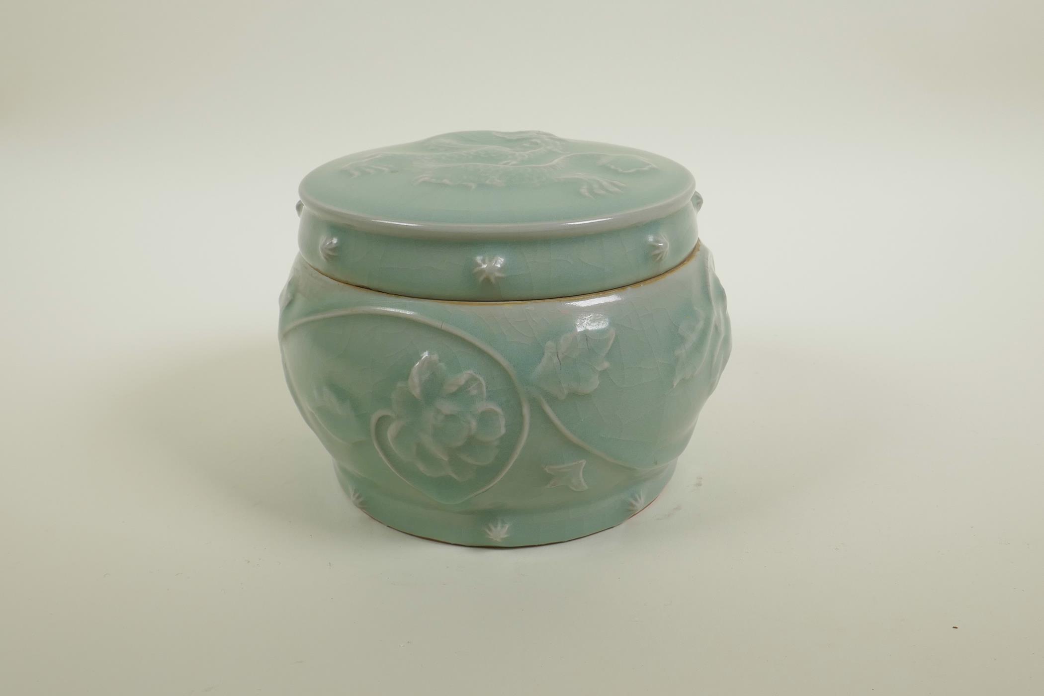 A Chinese celadon crackle glazed porcelain pot and cover with raised underglaze dragon and lotus