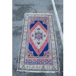 An Oriental pattern carpet with diamond shaped centre medallion on a blue ground within a yellow