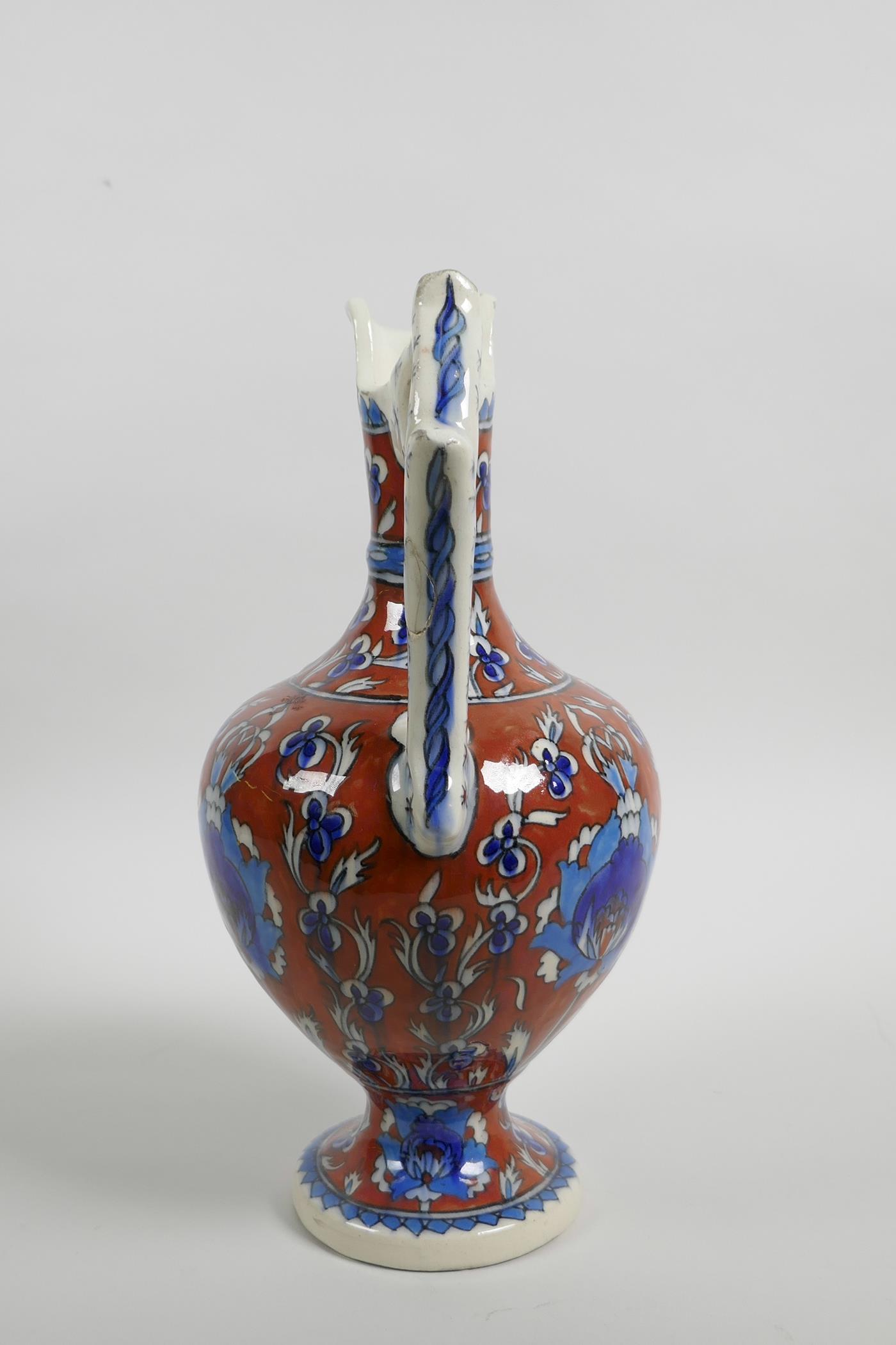 An early C20th Turkish Kutahya pottery ewer with traditional floral decoration, repair to handle, - Image 4 of 7