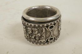 A Chinese white metal archer's ring with rotating central band decorated with figures