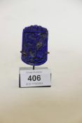 A lapis lazuli pendant with raised dragon decoration, mounted on a stand, pendant 2" high