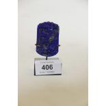 A lapis lazuli pendant with raised dragon decoration, mounted on a stand, pendant 2" high