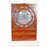 A Chinese carved and pierced hardwood screen housing a mirror, 37" x 25"