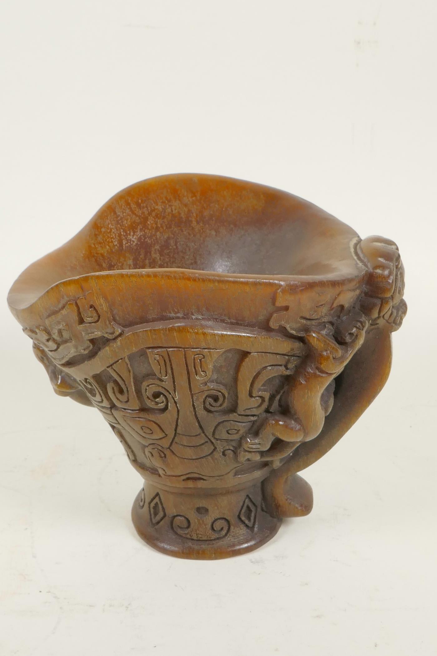 A Chinese faux horn libation cup decorated with archaic symbols and exotic beasts, 5" high