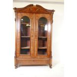 A Continental two door mahogany display cabinet with arch top and single drawer, canted corners