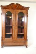 A Continental two door mahogany display cabinet with arch top and single drawer, canted corners