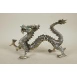 A Chinese filled white metal figure of a dragon, 10½" long