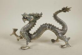 A Chinese filled white metal figure of a dragon, 10½" long