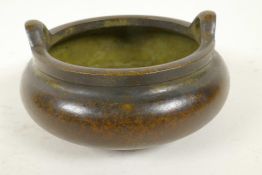 A Chinese bronze censer with two loop handles and raised on three feet, 4 character mark to base,