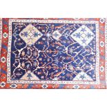 A Persian wool rug with a medallion design on a blue field, and red ground foliate borders, 33" x