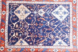 A Persian wool rug with a medallion design on a blue field, and red ground foliate borders, 33" x