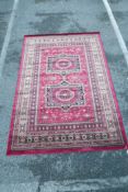 An Afghan style full pile red ground rug, 62" x 91"