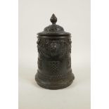 An antique Sino-Tibetan bronze container and cover with three kylin mask handles and decorated