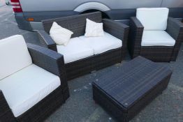 A contemporary woven garden suite consisting of two armchairs, a two seater sofa and coffee table,