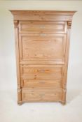 A Continental pine single drawer armoire with a false drawer, raised on turned supports, 40½" x