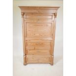 A Continental pine single drawer armoire with a false drawer, raised on turned supports, 40½" x