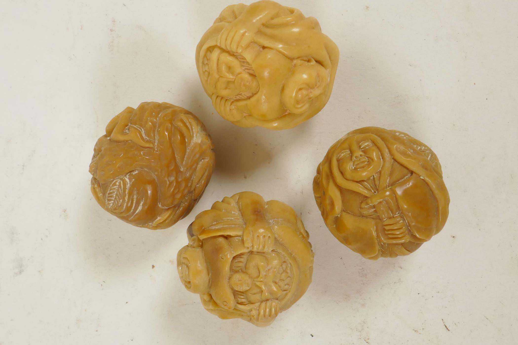 Four Oriental nuts carved with various figures, 1¼"