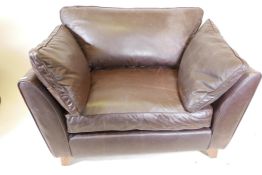 A contemporary brown leather armchair, 48" wide