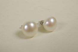 A pair of large cultured pearl stud earrings on silver posts