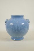A Chinese duck egg blue glazed vase with two lion mask handles and underglaze archaic decoration,