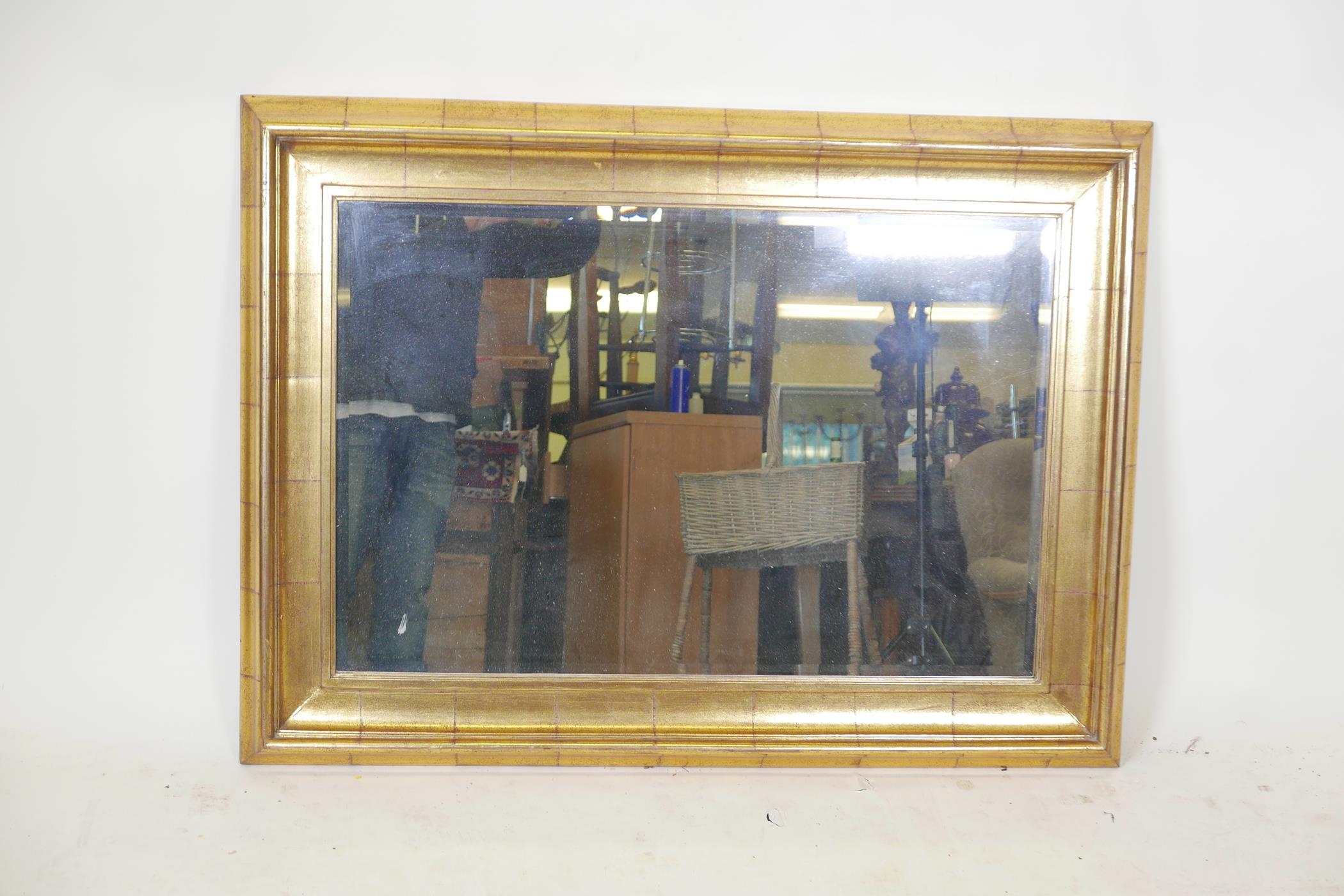 A gilt composition overmantle mirror with a cushion frame, 45" x 34"