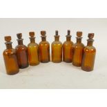 Eight antique amber glass chemist bottles with stoppers, 4½" high