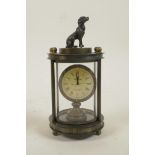 A brass cylinder desk clock with a knop in the form of a dog, 5" high