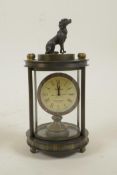 A brass cylinder desk clock with a knop in the form of a dog, 5" high