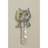 A sterling silver baby's rattle in the form of a cat's head with a mother of pearl style handle, 3"